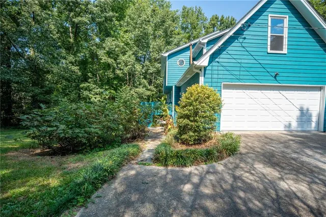 a backyard of a house with plants and outdoor seating
