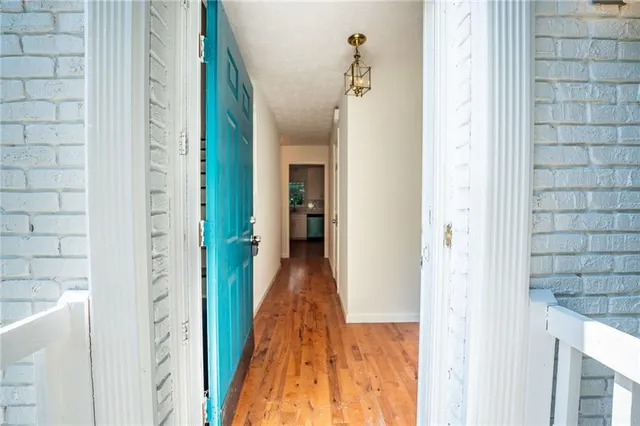 a view of a hallway with wooden floor and staircase