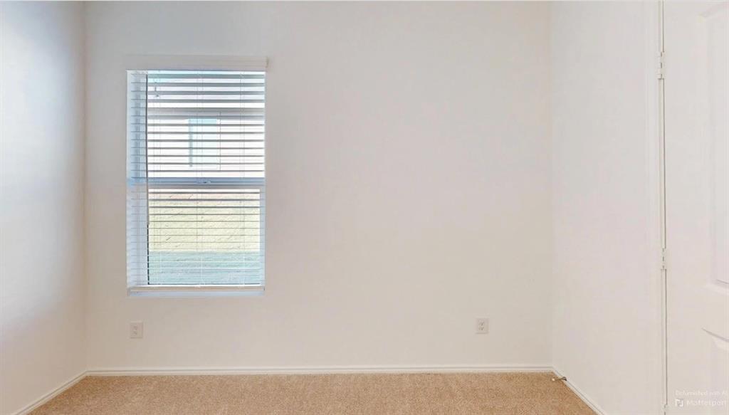 9757 Platteview Road Fort Worth, TX 76179 - Photo 12 of 19 Neutral-toned wall finishes, a single window with horizontal blinds, and tan carpeting
