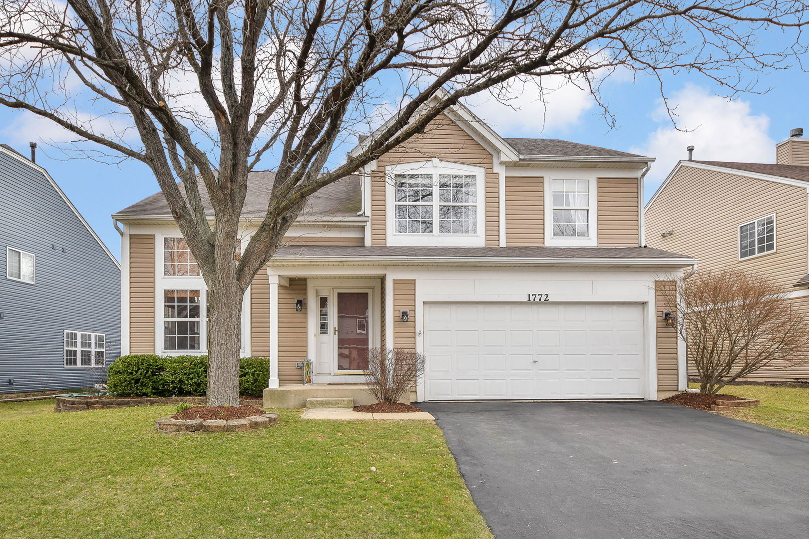 a front view of a house with a yard and garage