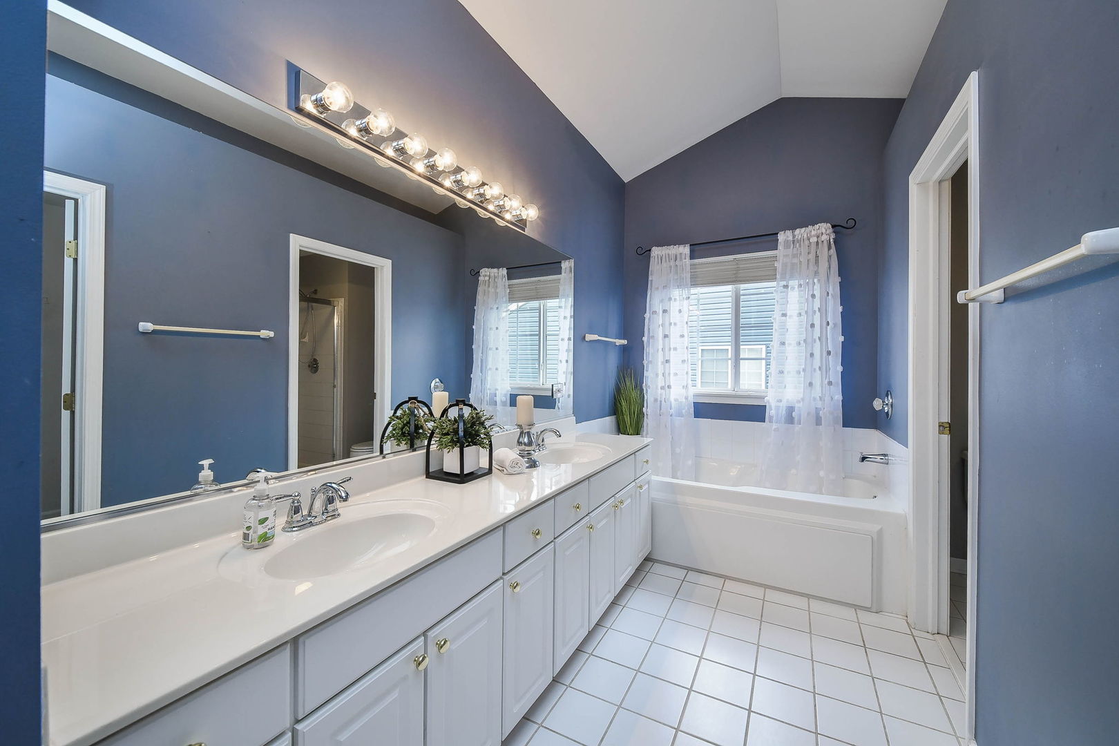 1772 Ellington Drive Aurora, IL 60503 - Photo 14 of 24 a bathroom with a tub a sink and a large mirror