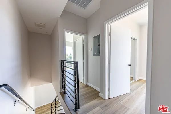 a view of a hallway with wooden floor and staircase