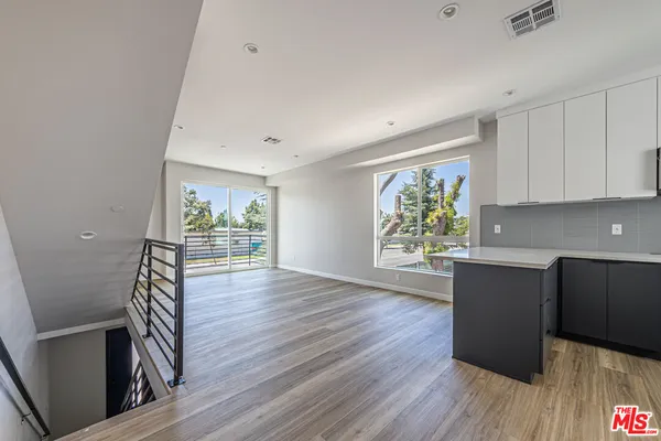 a view of a kitchen with furniture and wooden floor