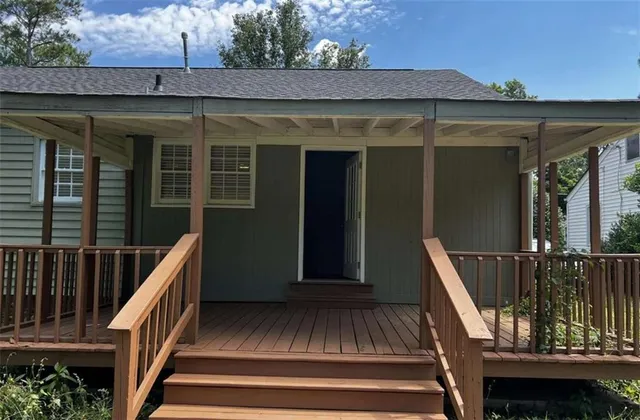 a view of a house with a yard and a large tree