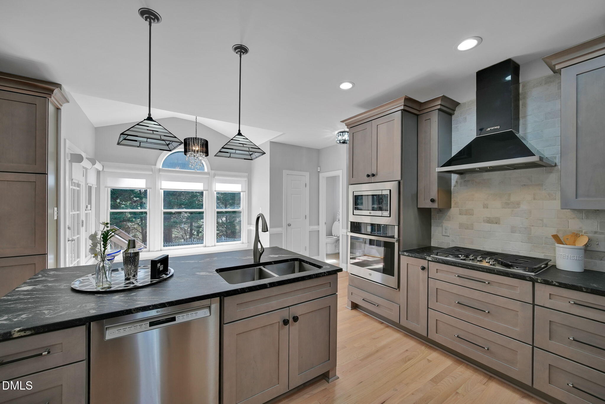 8005 Looking Glass Court Raleigh, NC 27612 - Photo 11 of 75 a kitchen with stainless steel appliances granite countertop a sink a stove and a wooden floor