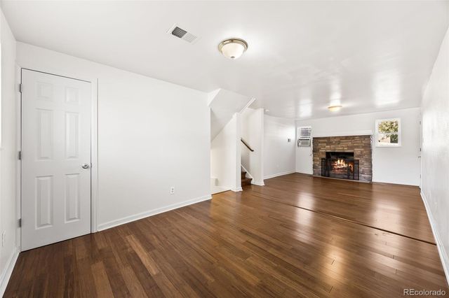a view of empty room with wooden floor and fireplace