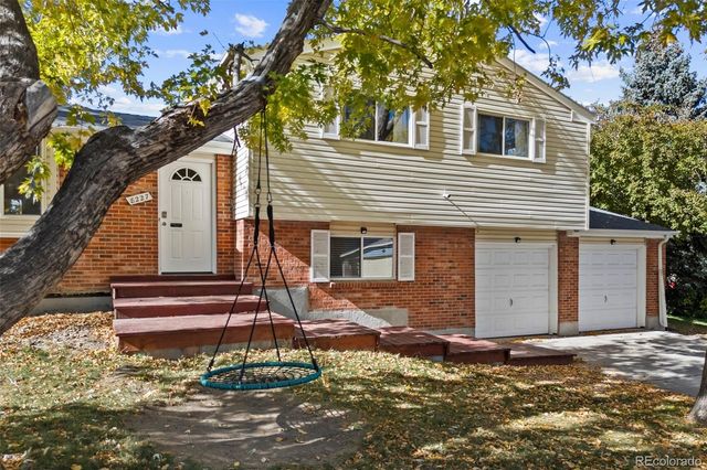 a front view of a house with a tree