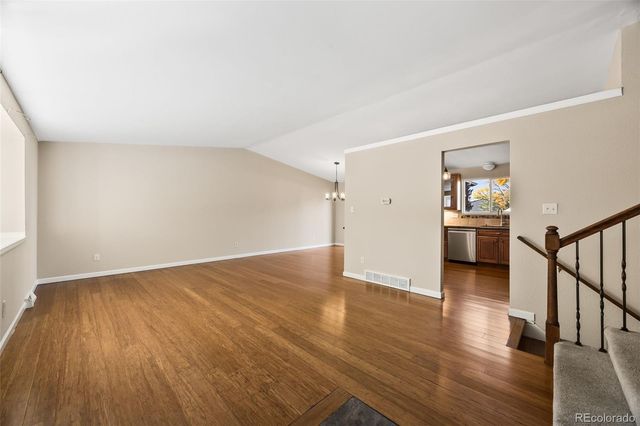 a view of a hallway with wooden floor and furniture