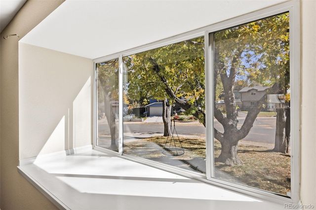 a view of a porch with a floor to ceiling window and tree