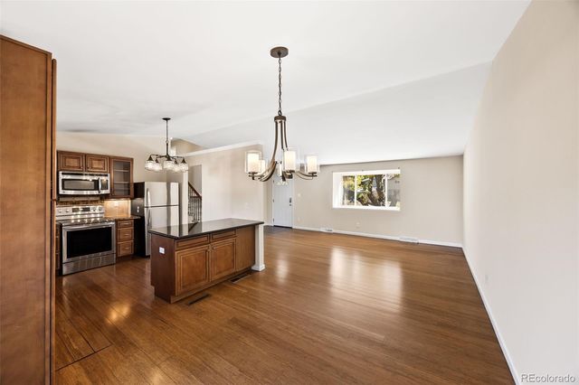 a view of a kitchen with a stove wooden floor kitchen view and a chandelier