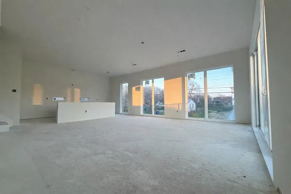 a large white room with windows and view of an empty room