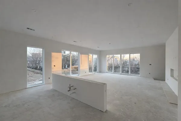 a view of an empty room with a fireplace and windows