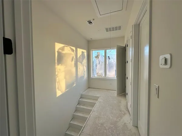 a view of an empty room with window and closet area