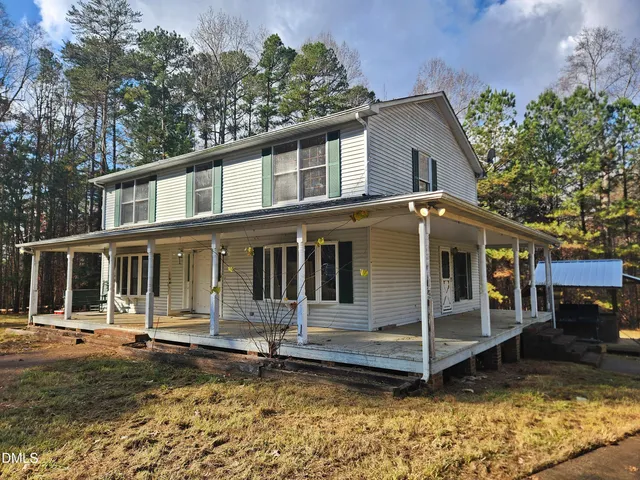 a view of a house with a yard and sitting area