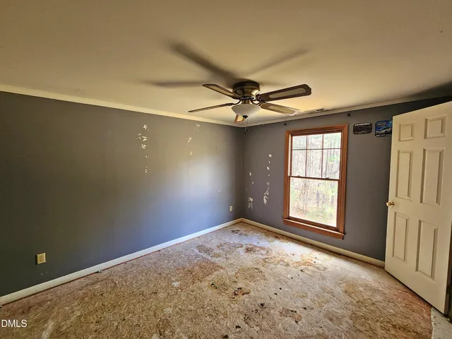 an empty room with closet and a chandelier fan