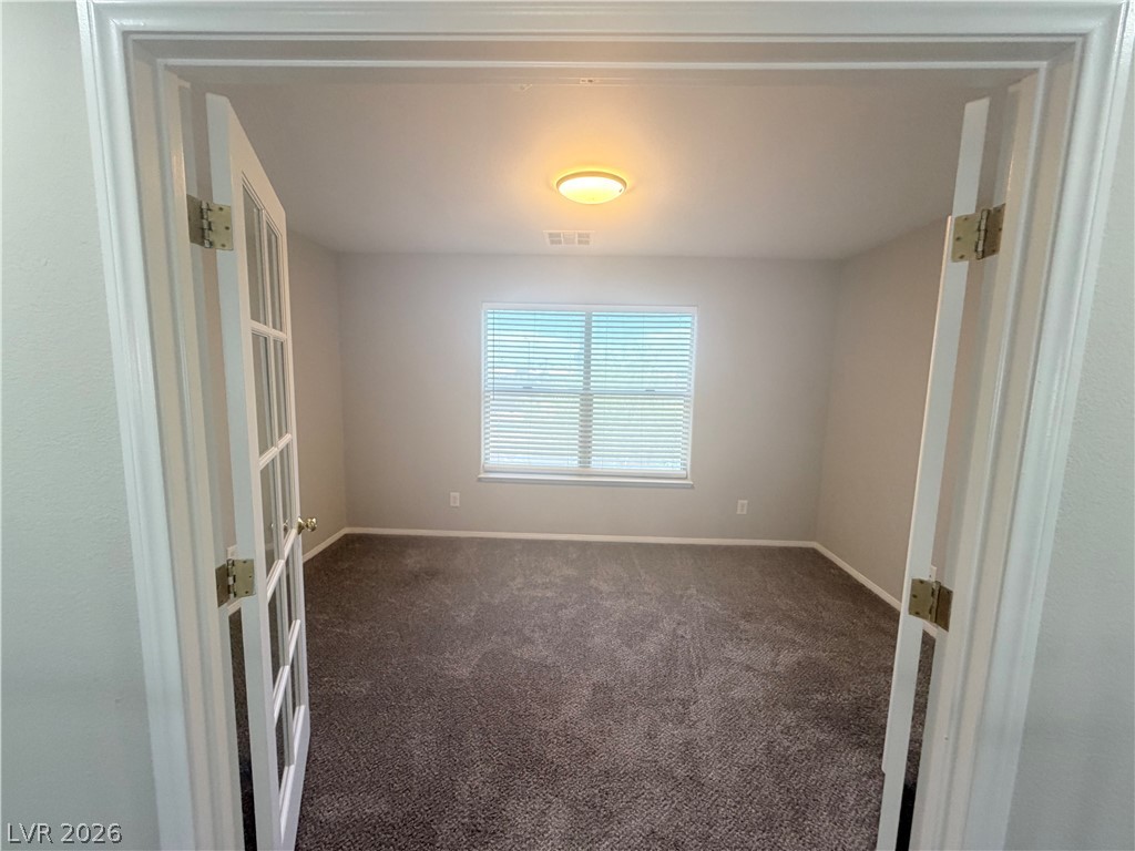 6116 Rabbit Track Street Las Vegas, NV 89130 - Photo 9 of 28 French doors open to a versatile room, well-lit and ready for your personal touch.