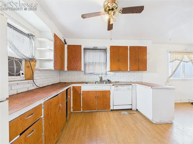 a kitchen with stainless steel appliances granite countertop a sink and dishwasher a stove with wooden floor