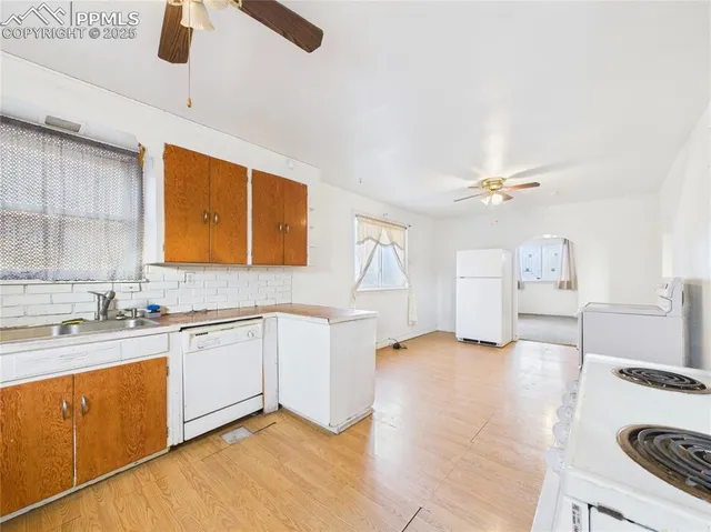 a view of a kitchen with sink a stove and furniture