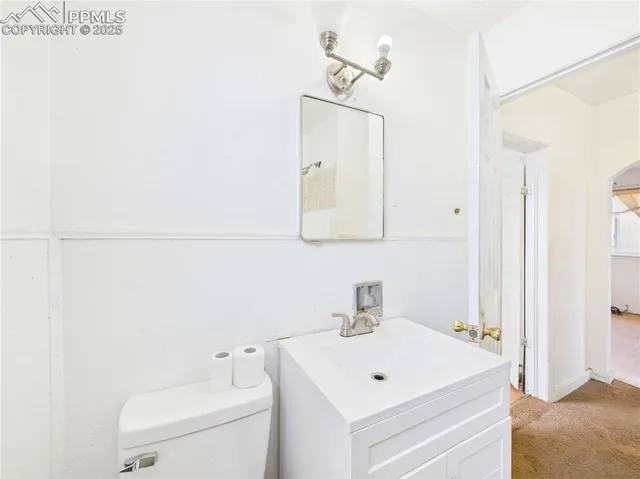 a bathroom with a toilet a sink and a mirror