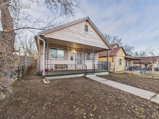 a view of a house with a yard and wooden fence