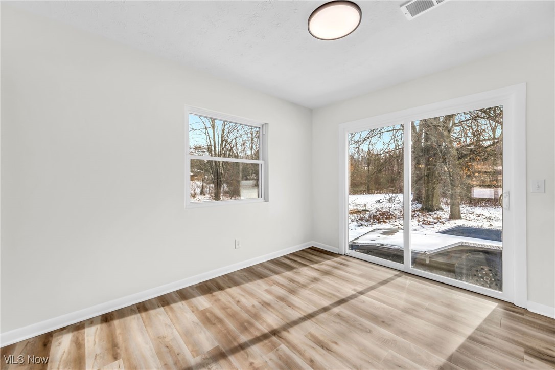 Unfurnished room with baseboards and light wood-style floors