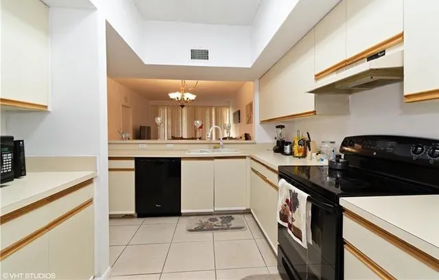 a kitchen with a sink a stove and cabinets