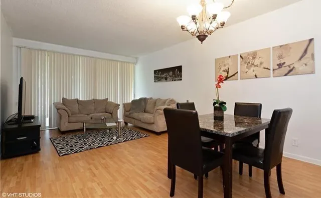 a living room with furniture a chandelier and a dining table