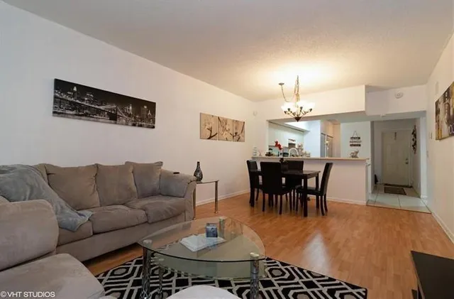 a living room with furniture a dining table and a chandelier