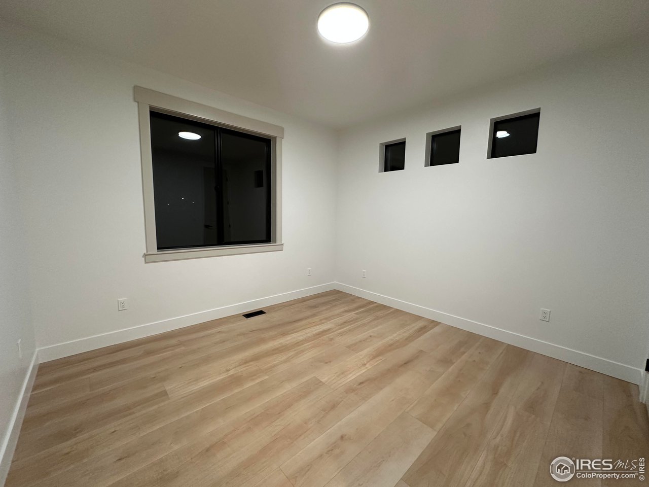 15276 Ypsilon Circle Mead, CO 80542 - Photo 32 of 40 a view of an empty room with wooden floor and a window