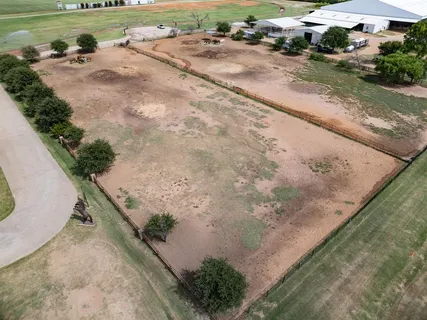 an aerial view of a house with a yard and lake