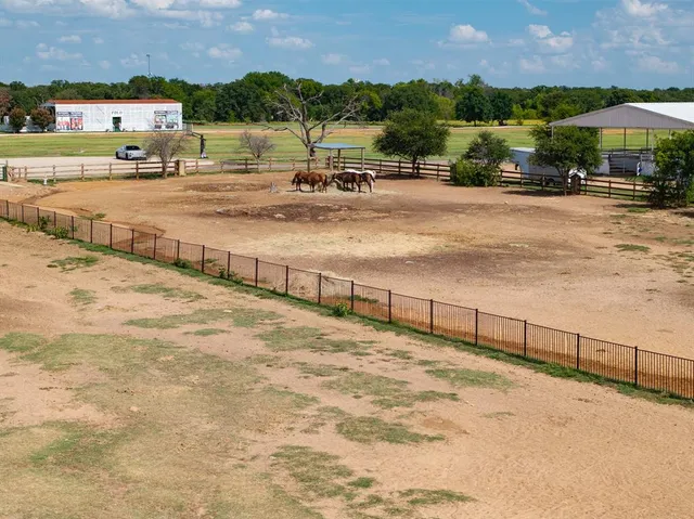 a view of a swimming pool with a lawn chairs under an umbrella