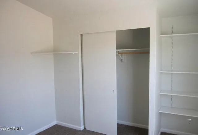 a view of walk in closet with empty racks