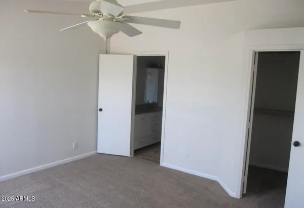 an empty room with a ceiling fan and a bathroom