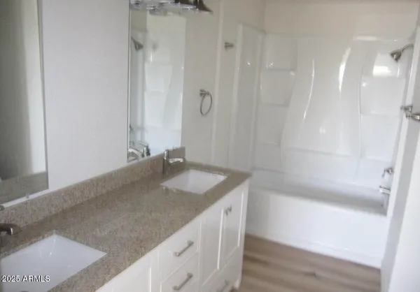 a bathroom with a granite countertop sink a toilet and shower