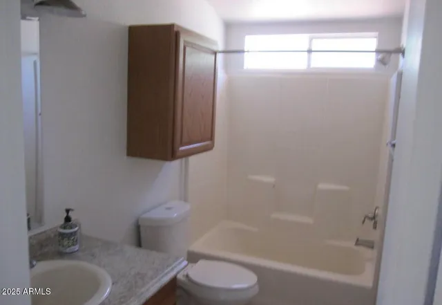 a bathroom with a granite countertop bathtub shower and toilet