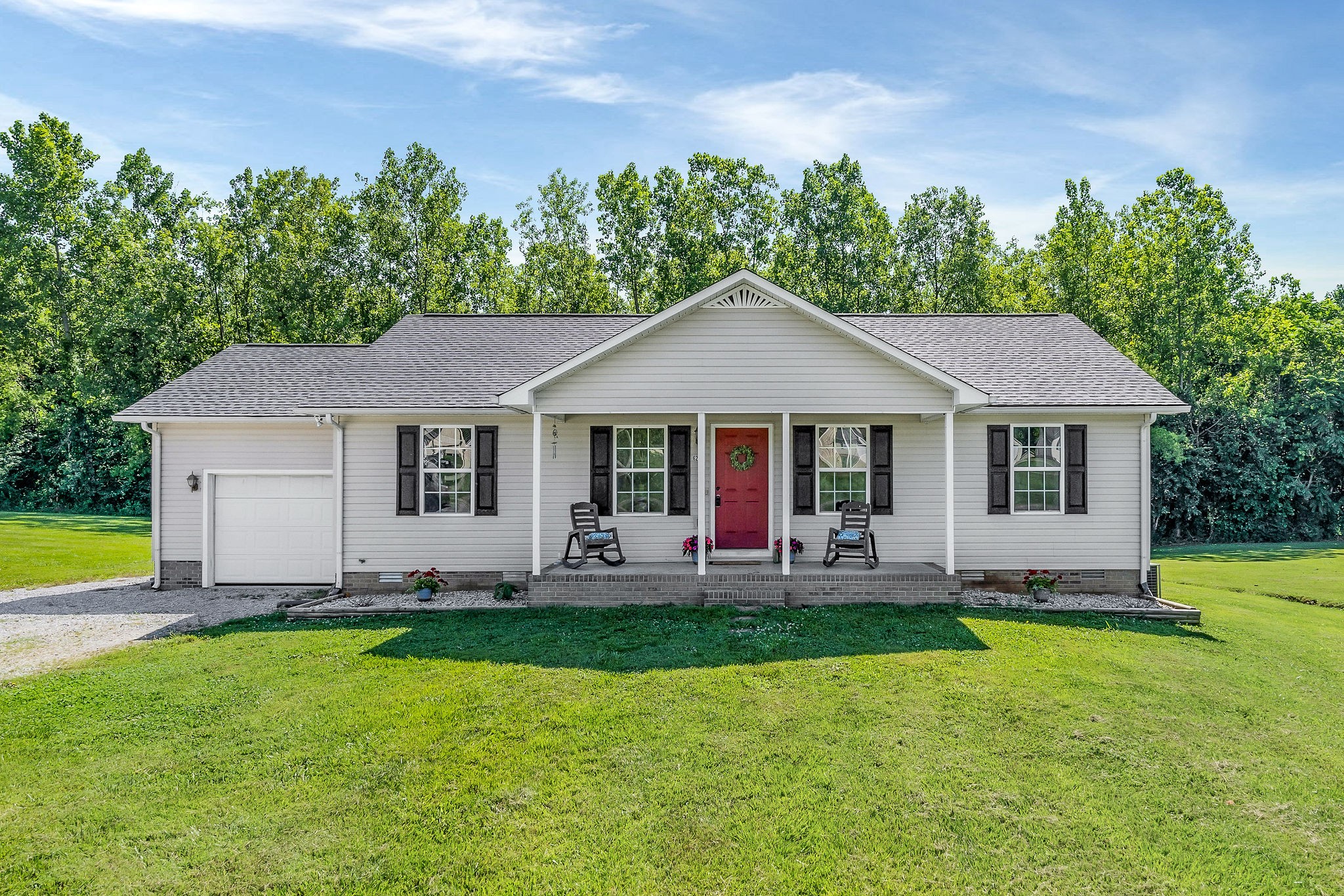 a front view of a house with a yard and trees