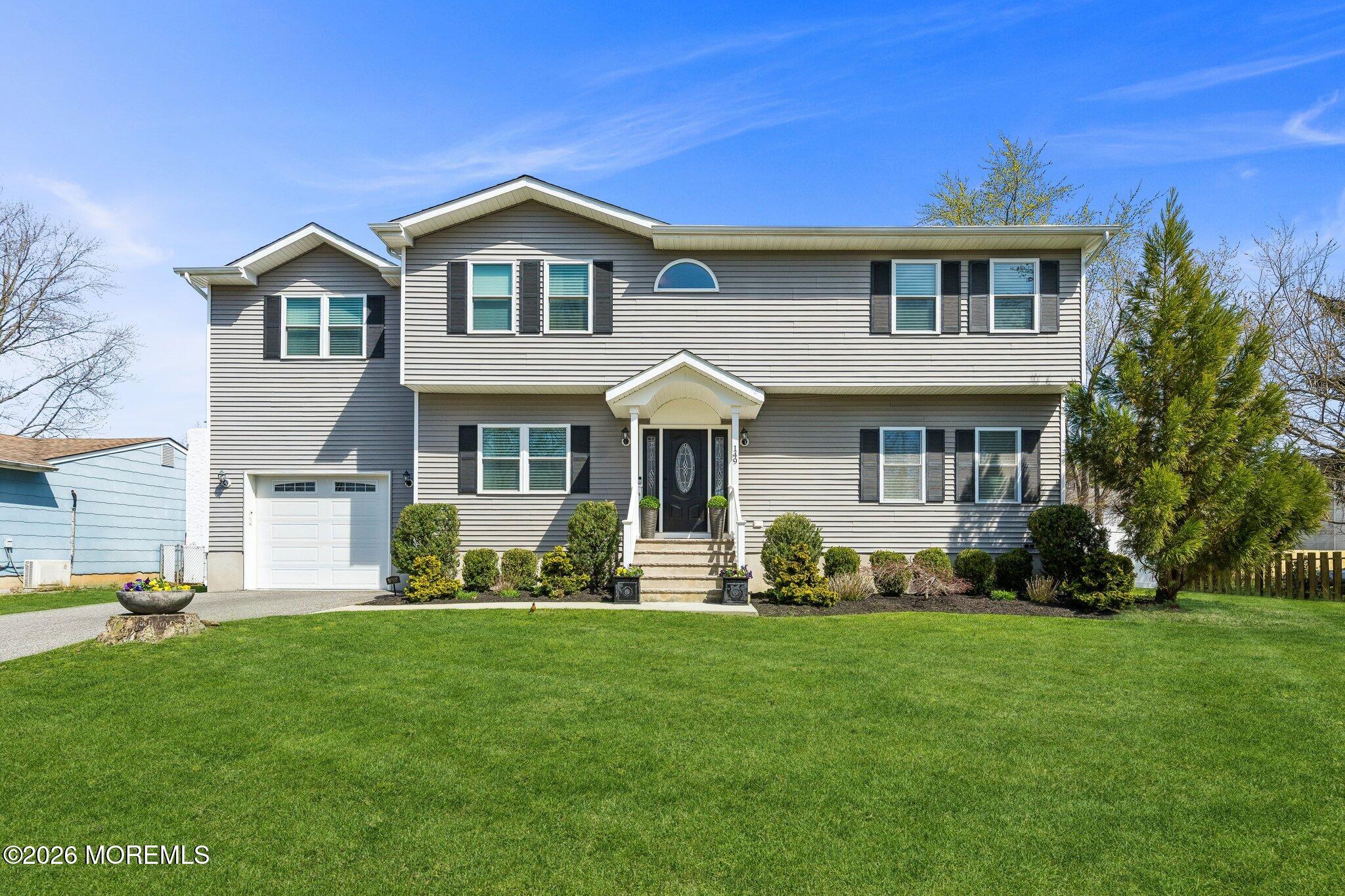 a front view of a house with a garden and yard