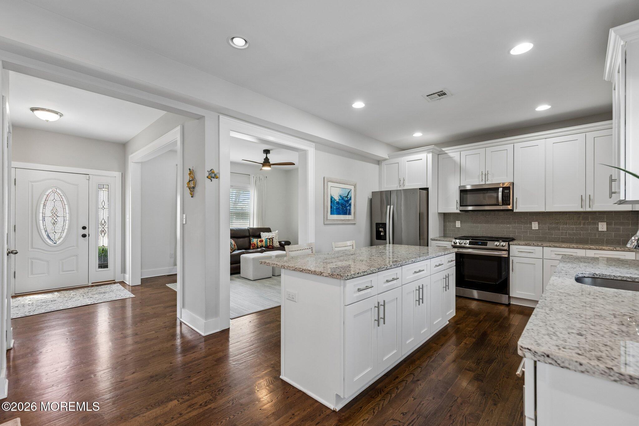 149 Berkeley Drive Brick, NJ 08724 - Photo 12 of 35 a large kitchen with stainless steel appliances granite countertop a lot of counter space and wooden floors