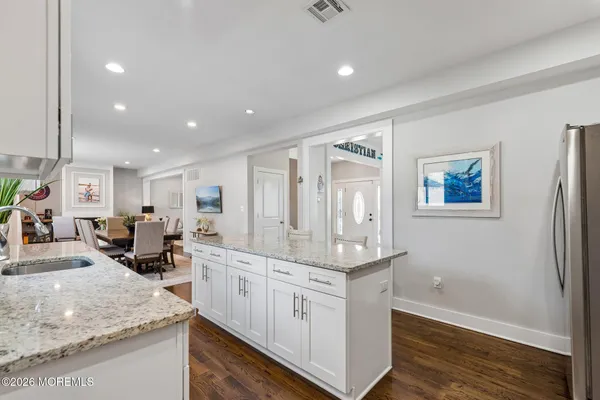 a kitchen with stainless steel appliances granite countertop a lot of counter space and wooden floors