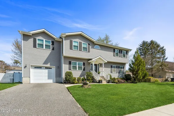 a front view of a house with a yard and trees