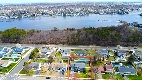 an aerial view of residential houses with outdoor space and lake view