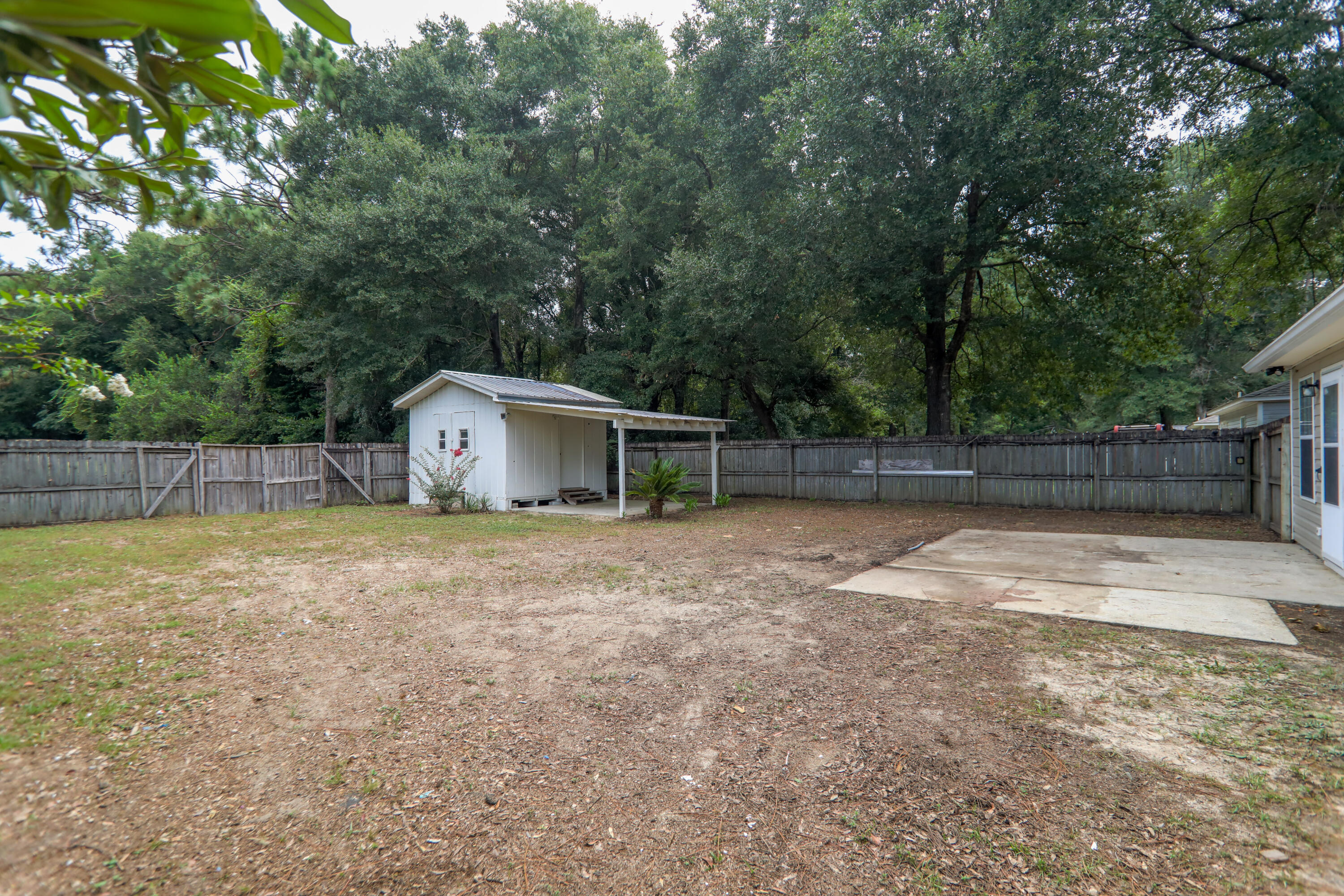 159 Patch Avenue Crestview, FL 32539 - Photo 8 of 11 a backyard of house with a slide and large trees
