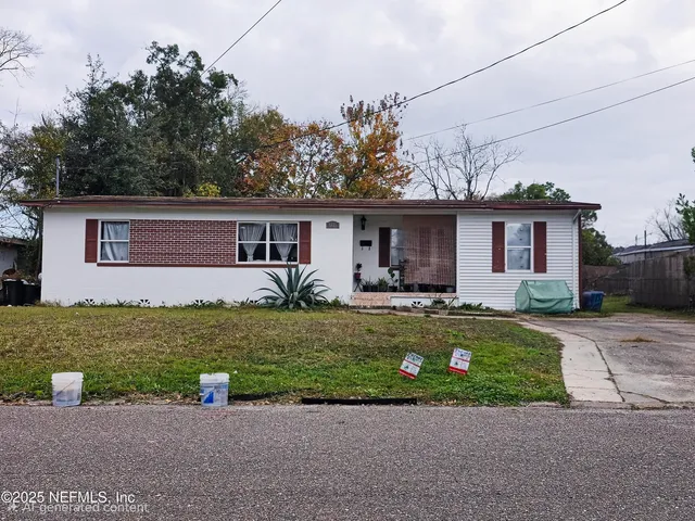 a front view of a house with a garden and yard