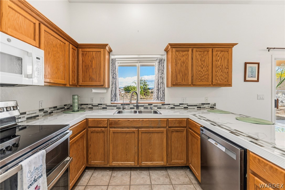 9332 Branded Road Kingman, AZ 86401 - Photo 11 of 44 a kitchen with a sink stove and cabinets