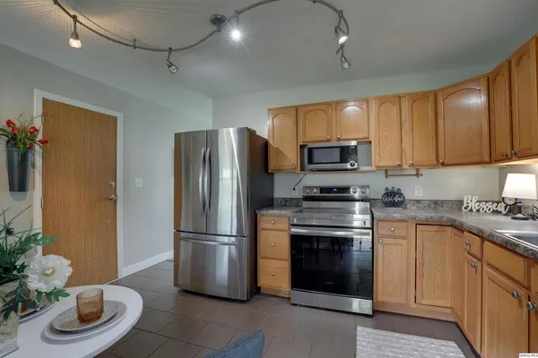 a kitchen with stainless steel appliances granite countertop a refrigerator a stove a sink and a microwave