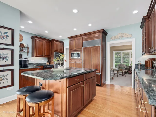 a kitchen with stainless steel appliances granite countertop table chairs sink and cabinets