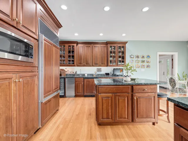 a kitchen with stainless steel appliances granite countertop a refrigerator and wooden cabinets