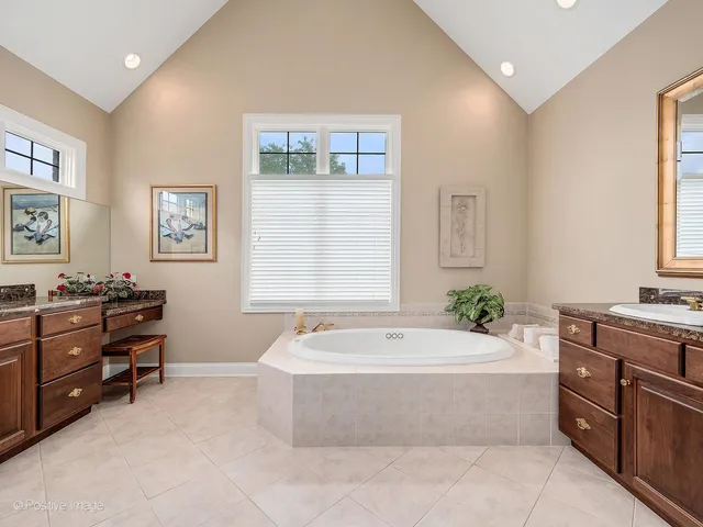 a spacious bathroom with a tub sink and mirror