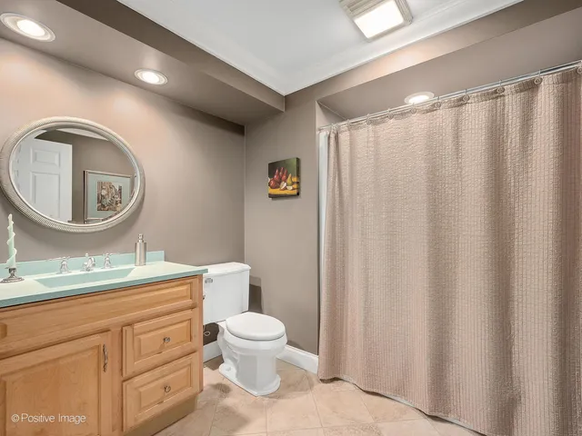 a bathroom with a toilet sink vanity and mirror