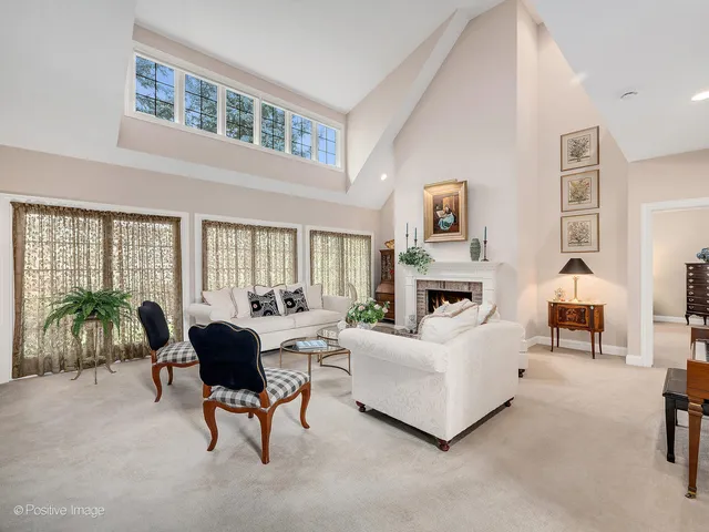 a living room with furniture a fireplace and a large window